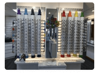 An optometry showroom with an extensive display of various eyeglass frames on sleek