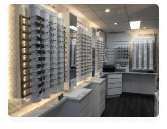 An optometry showroom with an extensive display of various eyeglass frames on sleek