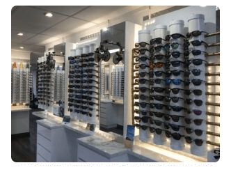 An optometry showroom with an extensive display of various eyeglass frames on sleek