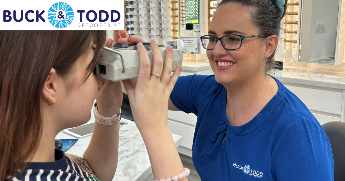 A patient tries on eyewear with the assistance of a smiling optometrist in a bright, welcoming optical shop.