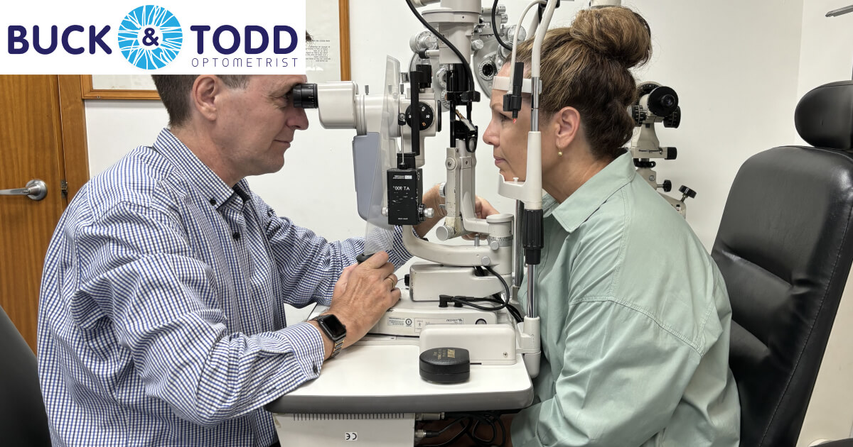 Optometrist conducts an eye examination using a slit lamp biomicroscope on a patient in a clinical setting, both focused on the eye health assessment process